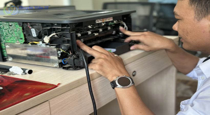 Kỹ thuât viên đang kiểm tra lượng mực trong máy in.